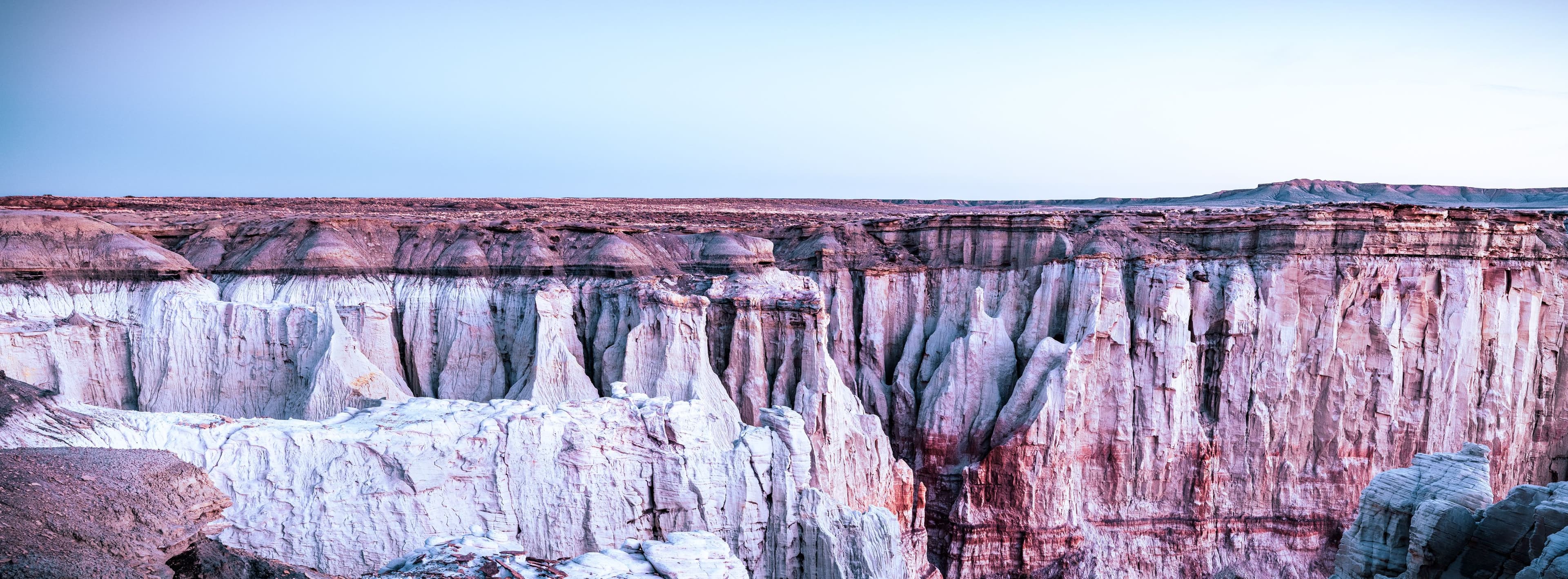 Golden morning light reveals layered sandstone cliffs in a silent desert canyon — a moment of profound stillness and timeless presence.